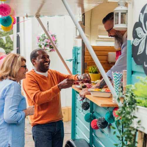 Older couple buying vegan food from a food truck